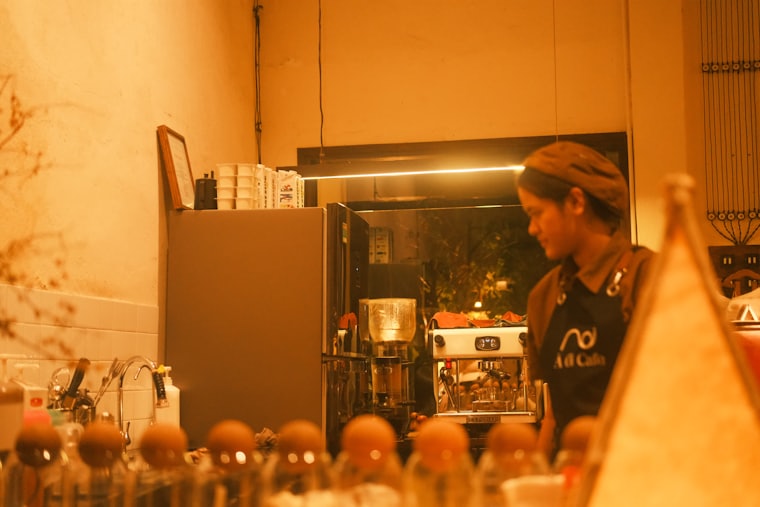 A barista working behind the counter of a small cafe