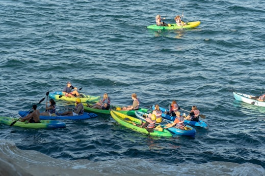 A group paddling sea kayaks along the coast